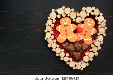 Ginger Bread Cookie Couple With Chocolate Hearts. Red Hot Candy In A Heart. On A Black Background. 