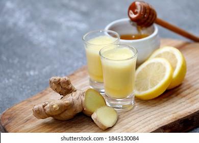 Ginger drink, shot, juice with healthy ingredients like ginger root, honey and lemon on wooden background. - Powered by Shutterstock