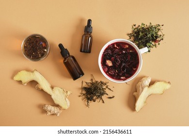 Ginger, Hibiscus Brewed Tea In A Cup And Two Dropper Bottles With Pipettes, Stress-reducing Supplements, Calming Drinks Top View Biege Background