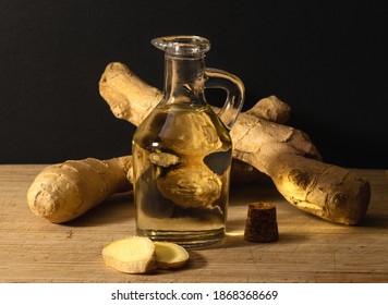 Ginger Oil In Glass Tube And Ginger Root.