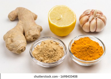 Ginger root, dry ginger and turmeric powder, garlic and lemon on white background. Food for immunity boosting. Top view