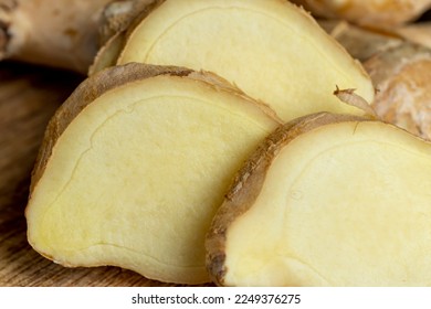Ginger root which is used for cooking in Asia, natural spicy ginger root on the kitchen board - Shutterstock ID 2249376275