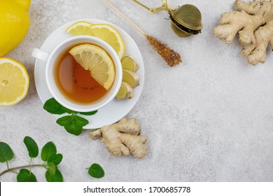 Ginger tea infusion in white cup with lemon slice, mint, honey. Hot healthy beverage on white background. Immune defence, vitamin c. Still life health care concept. Top view. Copy space. - Powered by Shutterstock