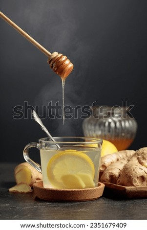 Ginger tea with lemon and honey on a black background.