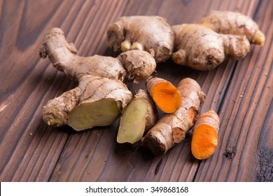 Ginger and turmeric roots on brown wooden background