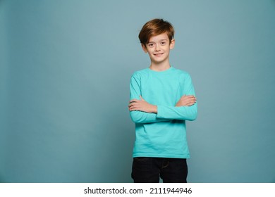 Ginger White Boy Wearing Long Sleeve Smiling And Looking At Camera Isolated Over Blue Wall