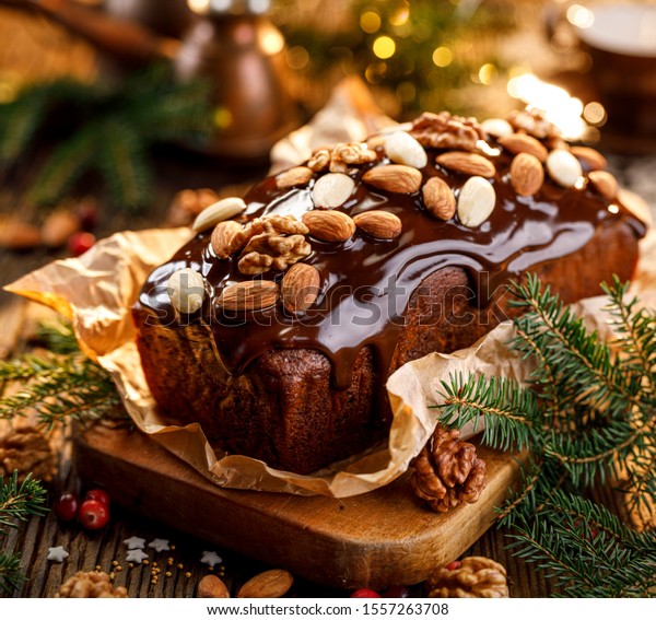 Gingerbread cake, Christmas\
gingerbread cake covered with chocolate and decorated with nuts and\
almonds on the holiday table. Christmas, traditional\
dessert