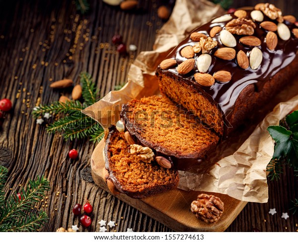 Gingerbread
cake, Christmas gingerbread cake covered with chocolate and
decorated with nuts and almonds on the holiday table, copy space,
top view. Christmas, traditional
dessert