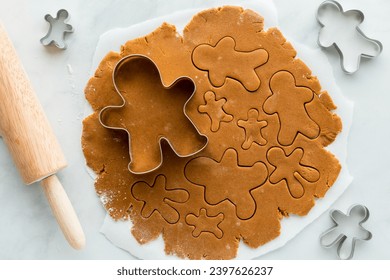 Gingerbread cookie dough rolled out and cut into gingerbread men.