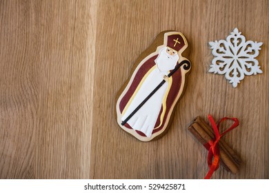 Gingerbread cookie of St. Nicholas with decorative snowflake and cinnamon at wood background. Christmas trees Cookies. - Powered by Shutterstock