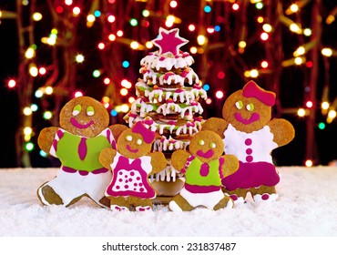 Gingerbread Cookies Family In Front Of Christmas Tree - Holidays Food Setting