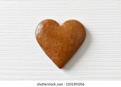 Gingerbread heart on a white background with a wood texture, can be used as a greeting card for Valentine's Day