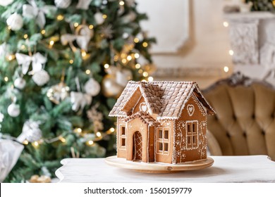 Gingerbread house, concept holiday of Christmas and Happy new year. Defocused lights of Christmas tree. Morning in the bright living room. Holiday mood.