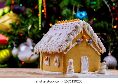 Gingerbread House On Color Lights Of Chrismtas Decorated Tree.