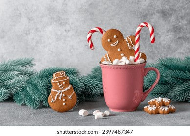 Gingerbread man in a cup with marshmallows and a candy cane, gray background. Christmas symbol. Selective focus. - Powered by Shutterstock