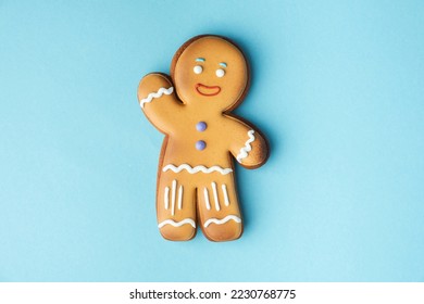 Gingerbread man decorated with white icing isolated on the blue pastel background. Flat lay. Traditional homemade Christmas cookies. Copy space - Powered by Shutterstock