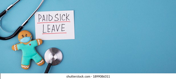 A Gingerbread Man In A Mask And A Medical Phonendoscope With The Inscription Paid Sick Leave On A Blue Background. FMLA Family Medical Leave Act