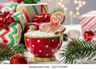 A gingerbread man is sitting in a red bowl with a white background. The bowl is decorated with green and red polka dots. The scene is festive and cheerful - Powered by Shutterstock