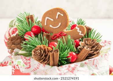 A gingerbread man is sitting in a wreath of pine cones and red berries. The wreath is decorated with candy canes and other festive decorations. Concept of warmth and joy - Powered by Shutterstock