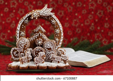 Gingerbread Nativity Scene And The Open Bible On Red Christmas Background