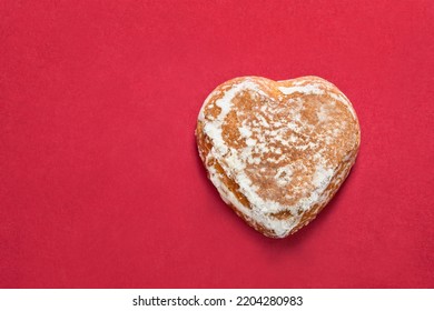 Gingerbread in the shape of a heart on red background