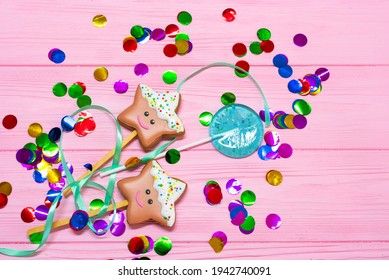 Gingerbread Star Cookies And Blue Lollipop On Pink Wooden Background Among Multicolored Confetti