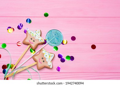 Gingerbread Star Cookies And Blue Lollipop On Pink Wooden Background Among Multicolored Confetti