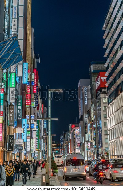 Ginza, Tokyo - December 2017 :\
Billboards, neon signs and People enjoying nightlife in crowded\
Chuo dori street at Ginza luxurious shopping District by\
night.