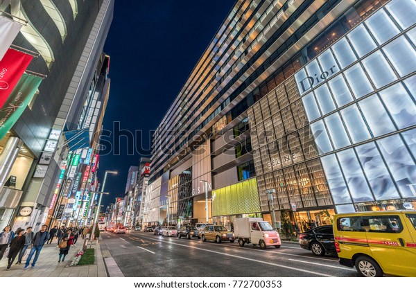 Ginza, Tokyo - December 2017 : Illuminated\
billboards in crowded Chuo dori street at Ginza luxurious shopping\
District by night.