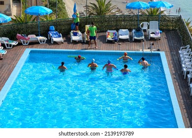 Gioiosa Marea, Sicily, Italy - June 25 2015: High angle view of the Hotel Capo Skino swimming pool in front of the sea with people exercising in the water