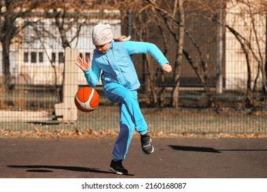 Girl 10 - 11 Years Old Plays Basketball Outdoors On The Sports Ground.