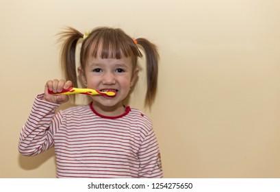 girl 2 years brushing her teeth