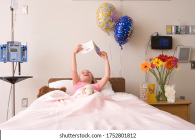 Girl 5 To 7 Reading Card In Hospital Bed