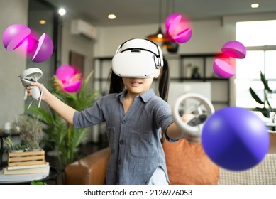 Girl 6 y.o. experiencing VR headset game at home.daughter wearing VR eyeglasses on the metaverse,Child playing metaverse gaming gadget for virtual reality,goggles at home.Virtual technology concept. - Powered by Shutterstock