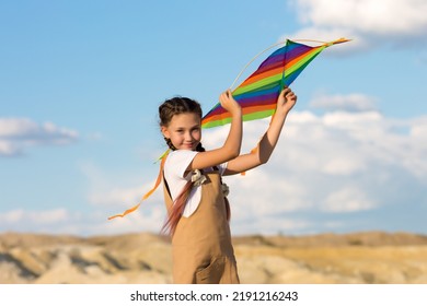 A Girl Of 8-9 Years Old Launches Kite Into The Sky,