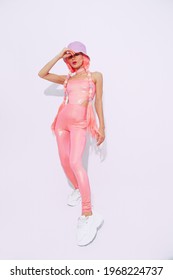 Girl 90s Style Posing In White Studio.  Bucket Hat. Trendy Pink Jumpsuit. Urban And Fashion Concept