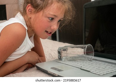 The Girl Accidentally Knocked Over A Glass Of Water On The Laptop. The Child Poured Water On The Computer Keyboard.