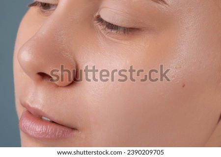 Girl with acne stick round acne patch on her cheek. Using acne patches for treatment of pimple and rosacea close-up. Facial rejuvenation cleansing cosmetology