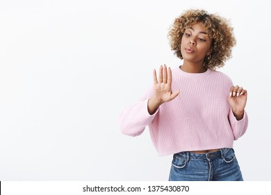 Girl acting as if she is not interested blowing on her nails after visiting salon, dying fingernails looking unbothered and chill delighted with good nail-polish standing over white background
