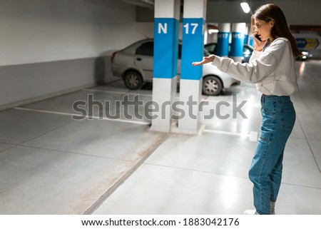 Girl after shopping discovered the loss of her automobile. Angry woman talking about missing car on phone. Vehicle theft concept