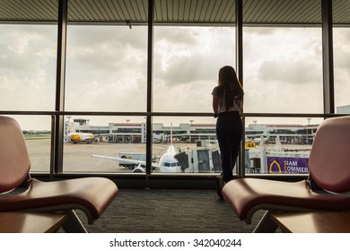 Girl at the airport window, Bangkok - August 6: Don Muang Airport on 3 November , 2015  Are available at Don Muang Airport in Bangkok, Thailand.