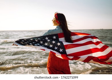 Girl With American Flag On The Beach At Sunset. 4th Of July. Independence Day. Patriotic Holiday.