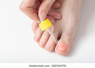 Girl applies nail oil to her toe to strengthen and improve the growth of the nail and cuticle. Copy space for text - Powered by Shutterstock