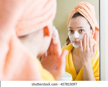 Girl Applying Face Pack In Front Of The Mirror At Home