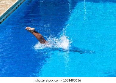 Girl asian diving action into blue swimming pool water with body submerged with legs feet out overhead photo. - Powered by Shutterstock