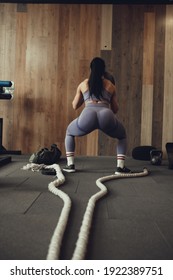 A Girl Athlete With A Pumped-up Booty Squats With A Phyto Ball Near The Wall