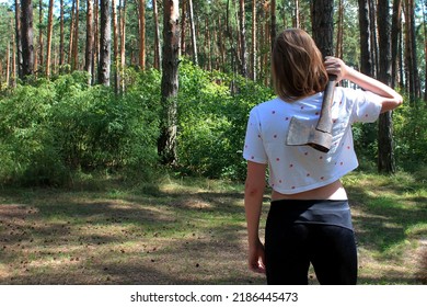 a girl with an ax in her hand in a pine forest, a girl holds a rusty ax, a girl goes to chop wood in the forest, cut down the forest, a rusty hand ax, woman holding an wooden handled axe