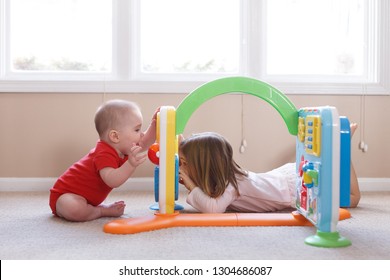 Girl And Baby Boy Playing Peekaboo