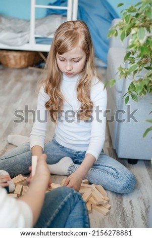 girl with baby brother playing on the floor in a game of django. High quality photo