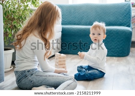 girl with baby brother playing on the floor in a game of django. High quality photo